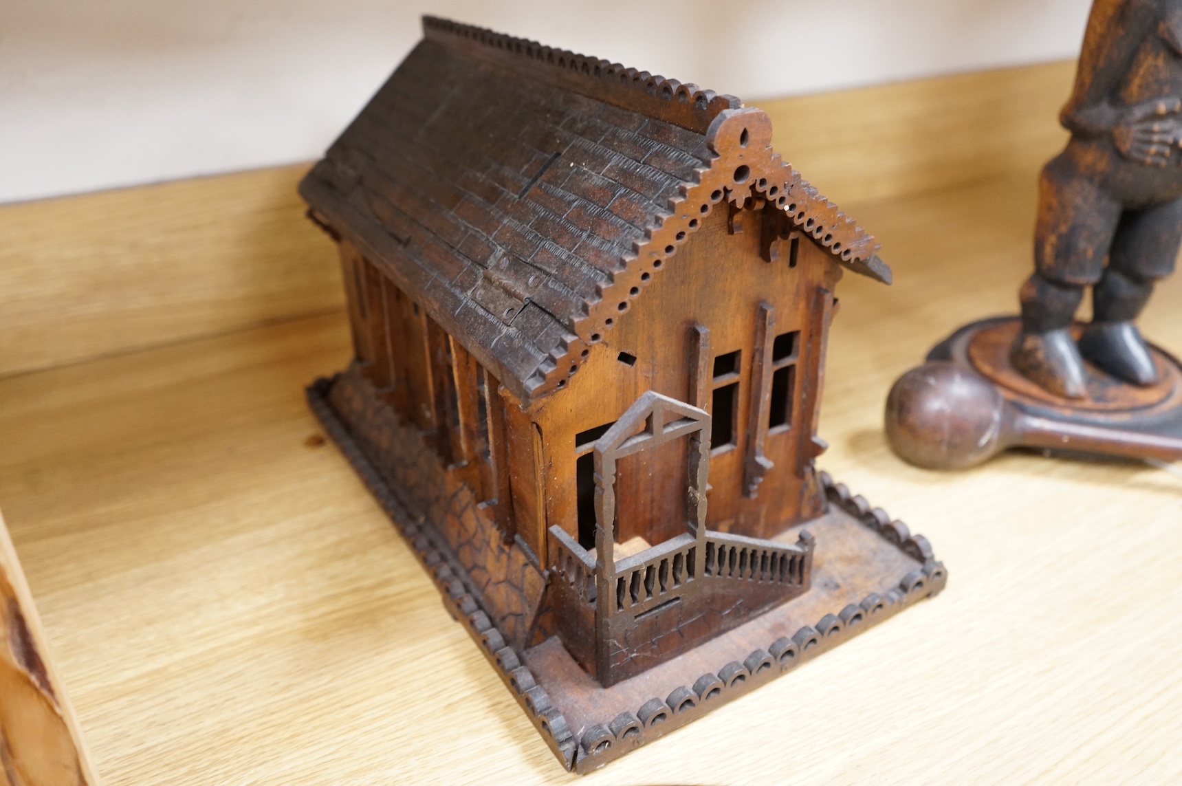 An early 20th century Black Forest carved walnut musical footed dish together with a model of a house (2)